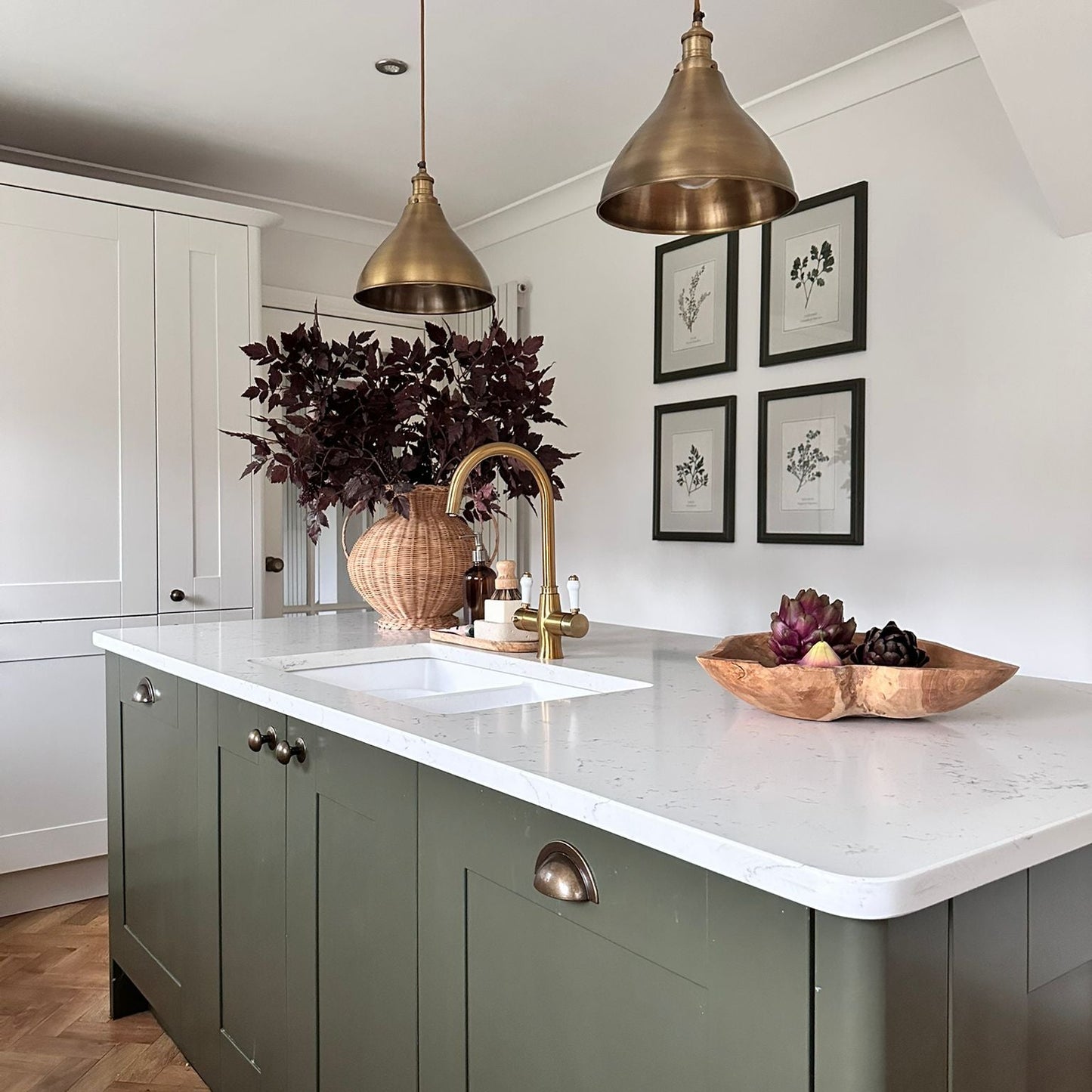 Modern kitchen with a central island, white countertop, and decorative elements.