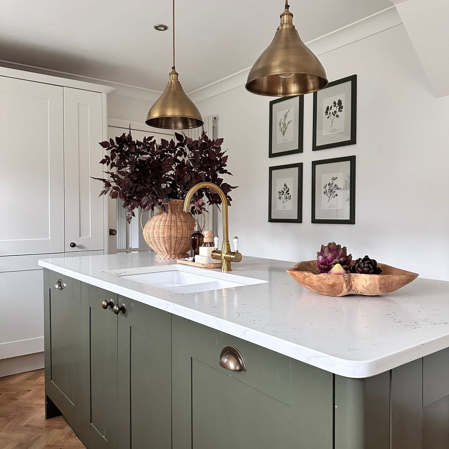 Modern kitchen with a central island, white countertop, and decorative elements.
