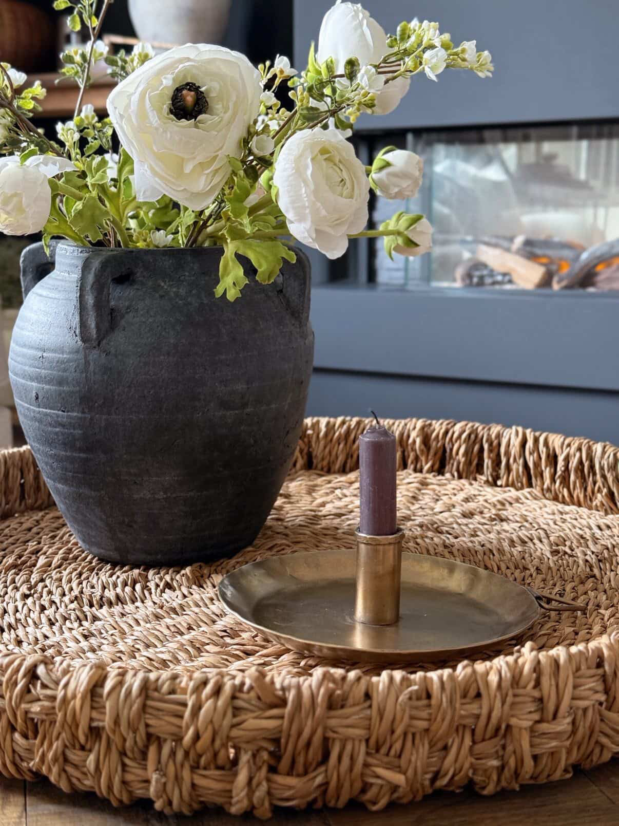 Decorative vase with white flowers on a woven surface