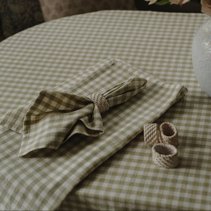 Green checkered tablecloth with folded napkin on a table, surrounded by decorative elements.