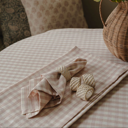 Decorative setting with a checkered tablecloth, folded napkin, and decorative elements on a table.