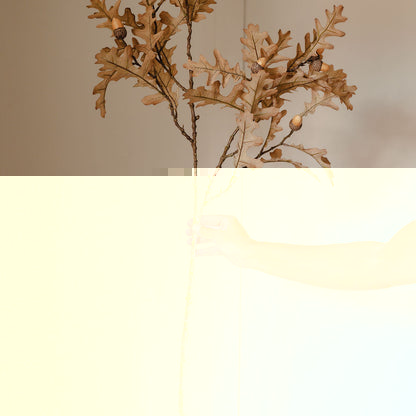 Hand holding a dried plant against a neutral background