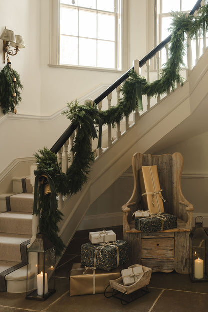 Cedar cypress swag styled with a bell and velvet ribbon for Christmas