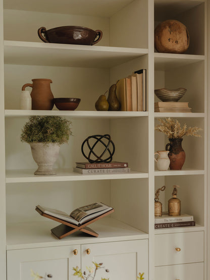 Ceramic pears styled on shelf with faux foliage and books