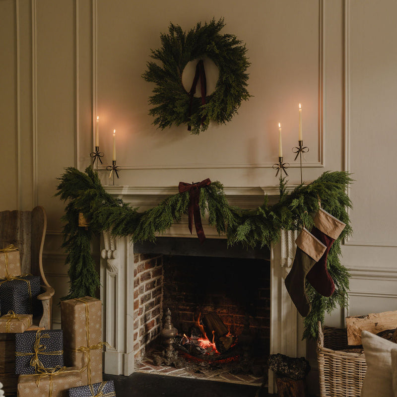 Faux cedar wreath styled with cowbells and green velvet ribbon